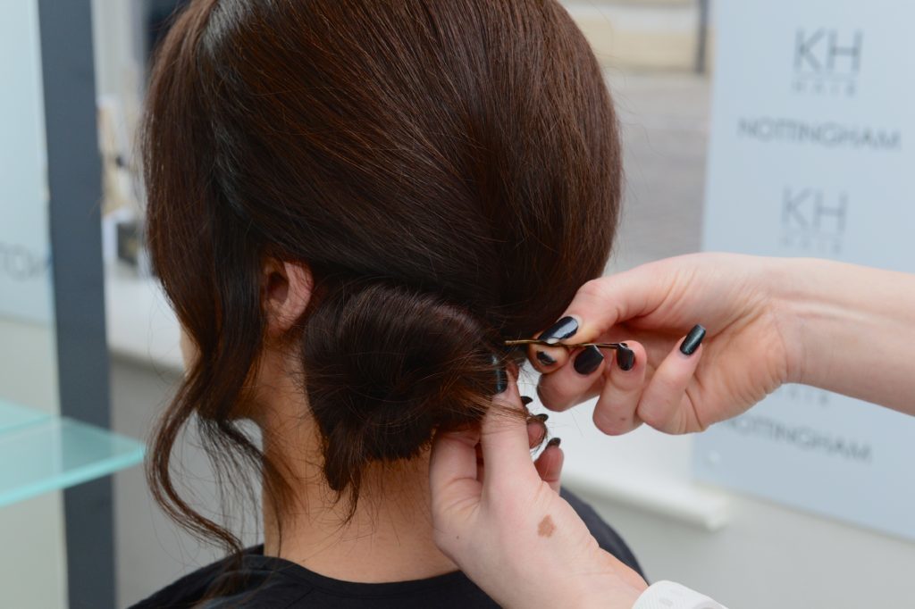 Hair grips being put in dark hair
