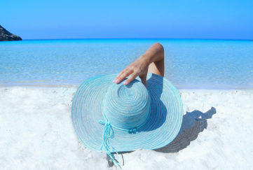 Woman on beach in blue hat
