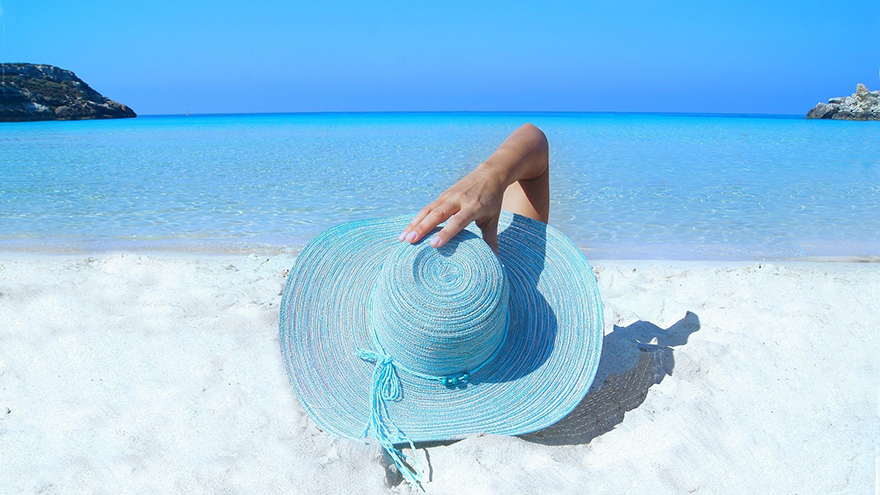 Woman on beach in blue hat