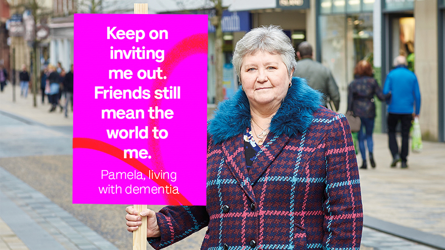 Woman in checked coat with sign