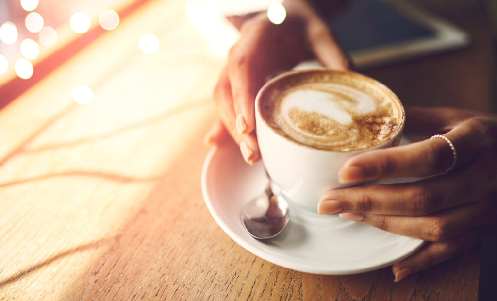 Closeup shot of an unrecognizable woman having a cup of coffee at a cafe