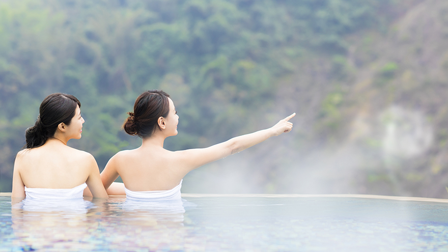 happy young woman relaxing in hot springs