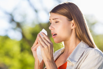 Beautiful woman using tissue while sneezing