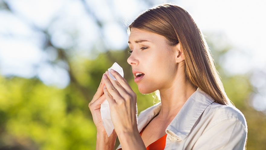 Beautiful woman using tissue while sneezing