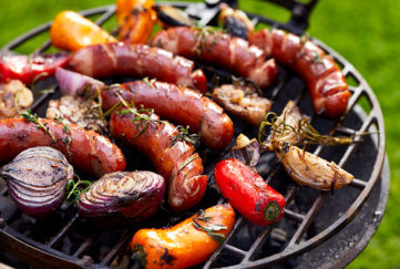 Grilled sausages and vegetables on a grilled plate, outdoor. Grilled food, bbq