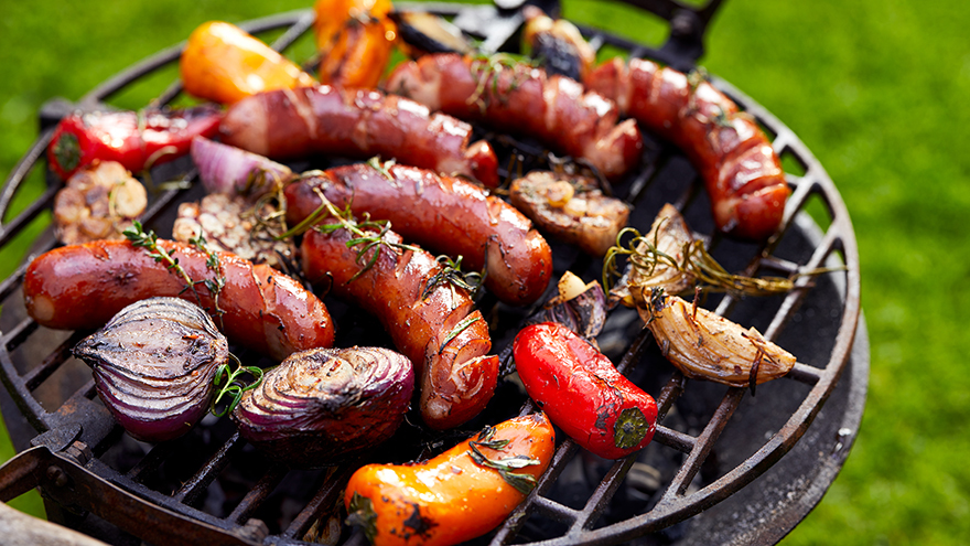 Grilled sausages and vegetables on a grilled plate, outdoor. Grilled food, bbq