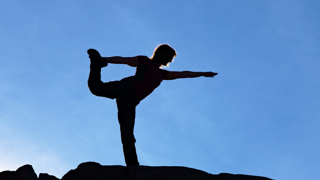 Woman doing yoga on hilltop