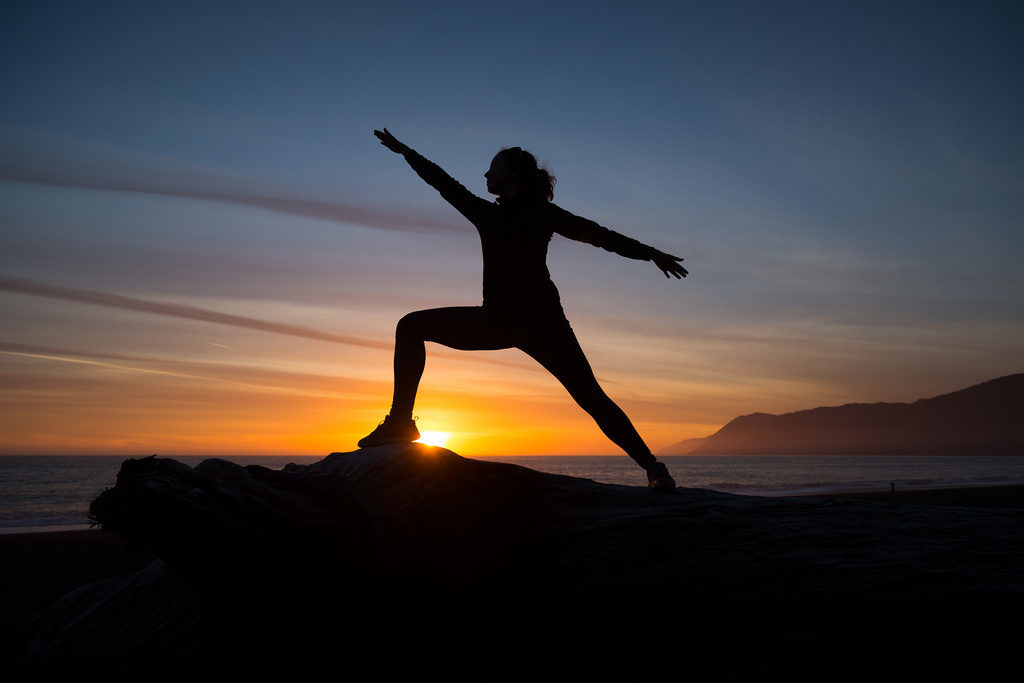 Woman doing yoga at sunset