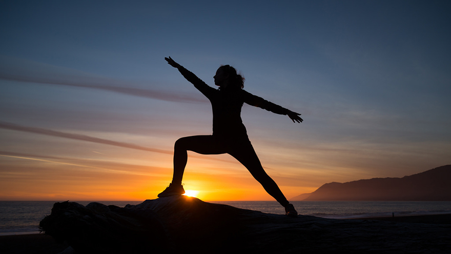 Woman doing yoga at sunset