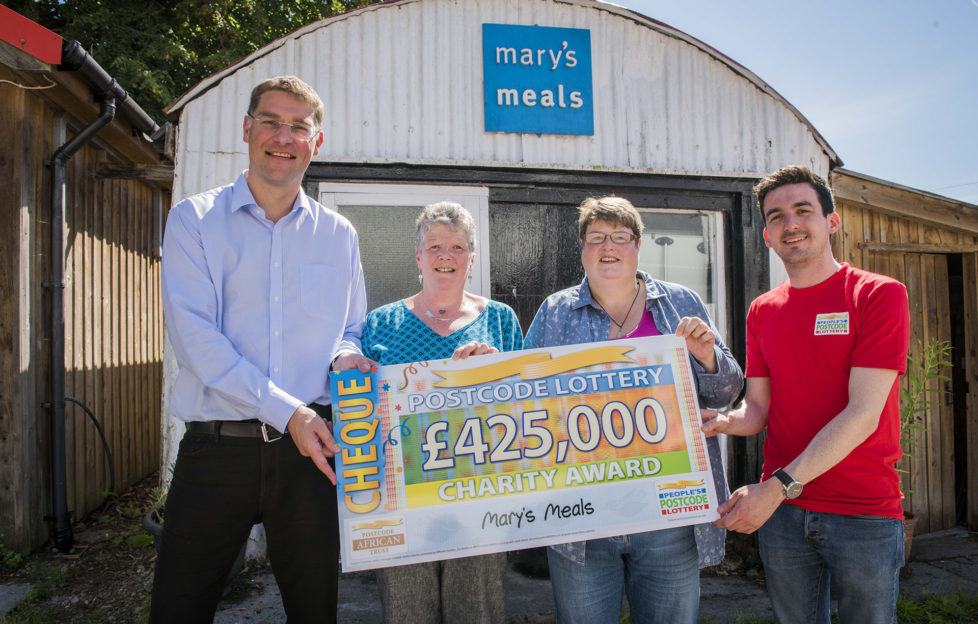 Magnus receiving a cheque from the People's Postcode Lottery presenter, along with two winners from the lottery Pic: Chris Watt
