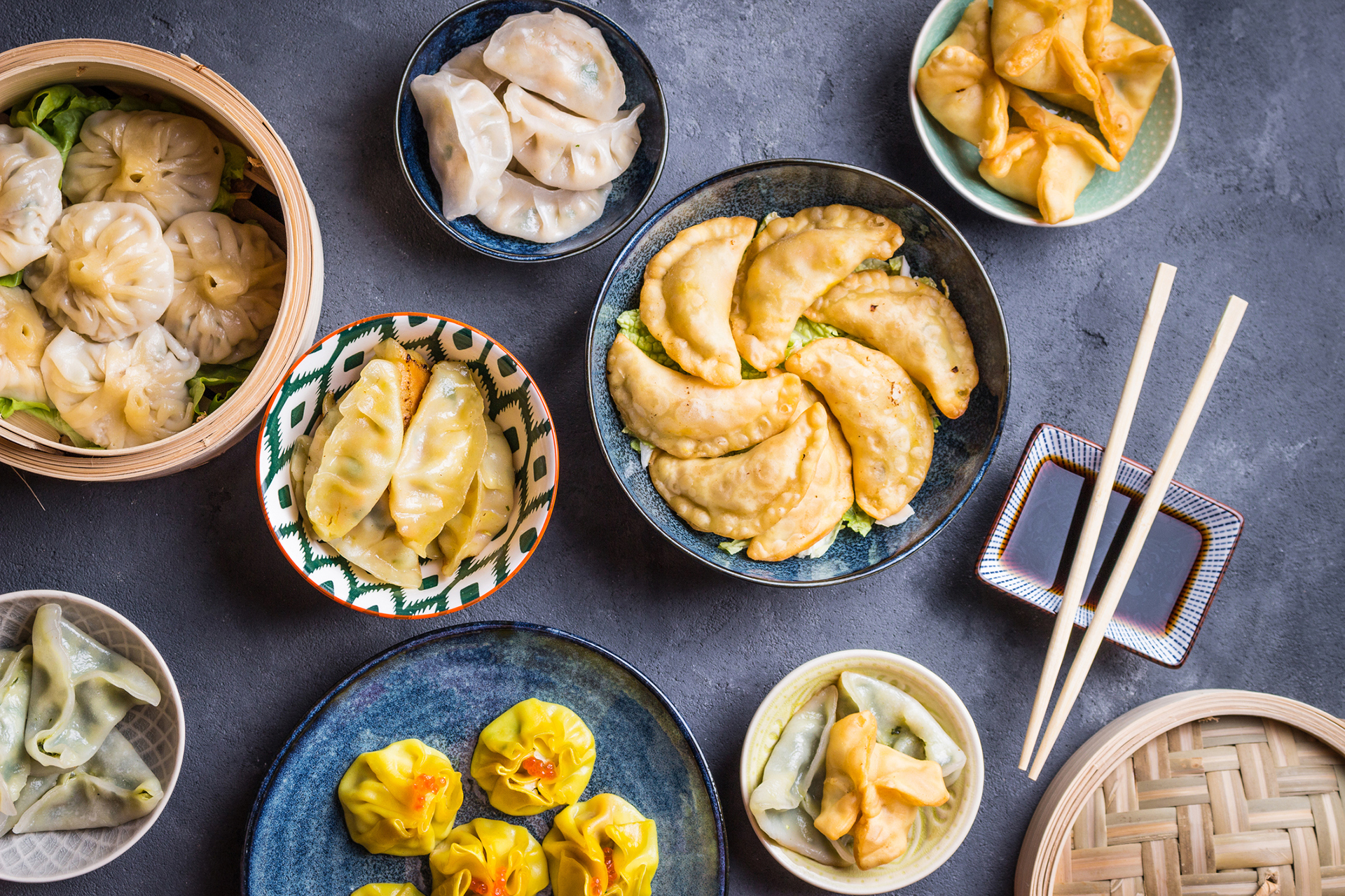 Assorted dim sum appetizers on rustic background. Set of Chinese food for share. Asian buffet. Traditional Chinese dim sum food. Top view. Different Chinese dumplings and snacks on table