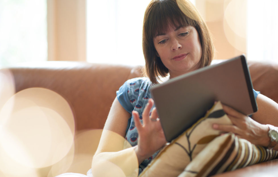 Mature woman browsing the internet on a digital tablet