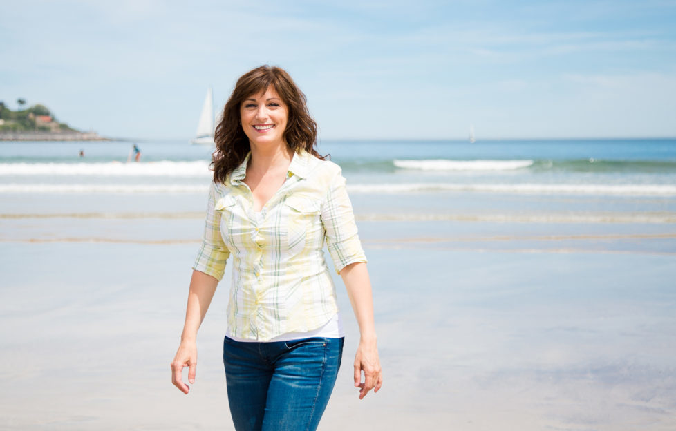 woman walking along the shore on the beach