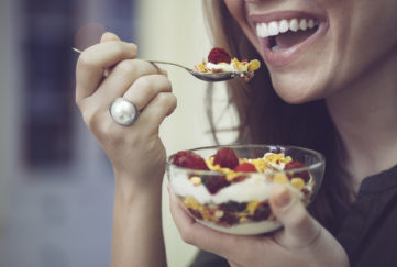 Young woman is eating breakfast cereal