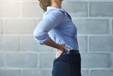 Cropped shot of a businesswoman suffering from back pain
