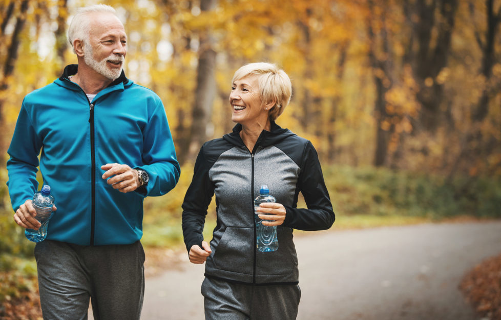 Senior couple jogging in a forest.