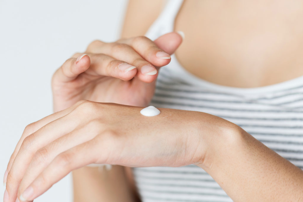 Woman applying cream to her hands