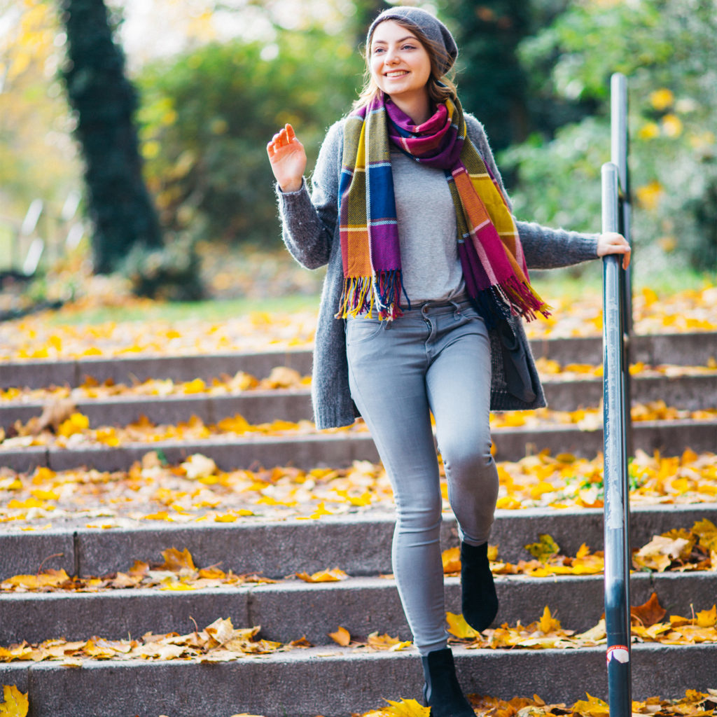 woman walking down the steps in a park in autumn.