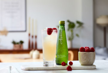 Guava and lychee mocktail in tall glass with bottle of Appletiser