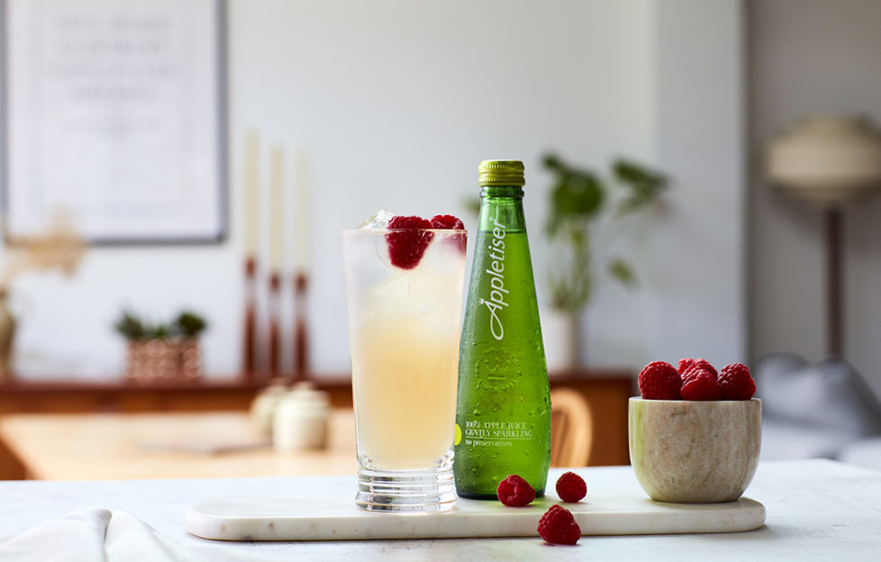 Guava and lychee mocktail in tall glass with bottle of Appletiser