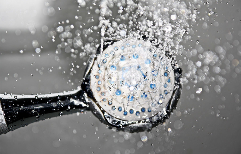 Looking up at shower head raining down water