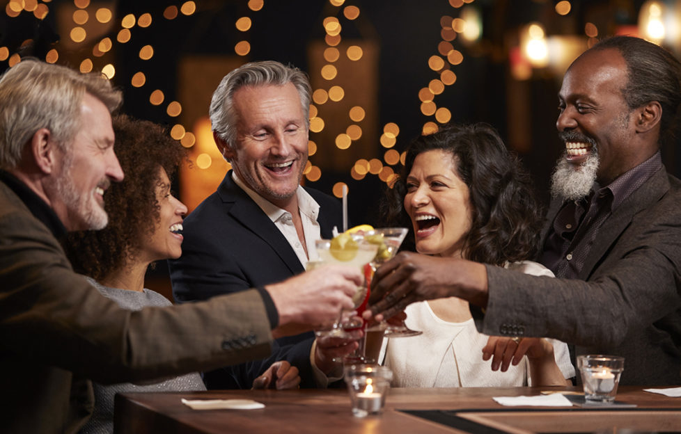 Group Of Middle Aged Friends Celebrating In Bar Together