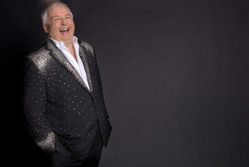 Christopher Biggins in a black and silver suit