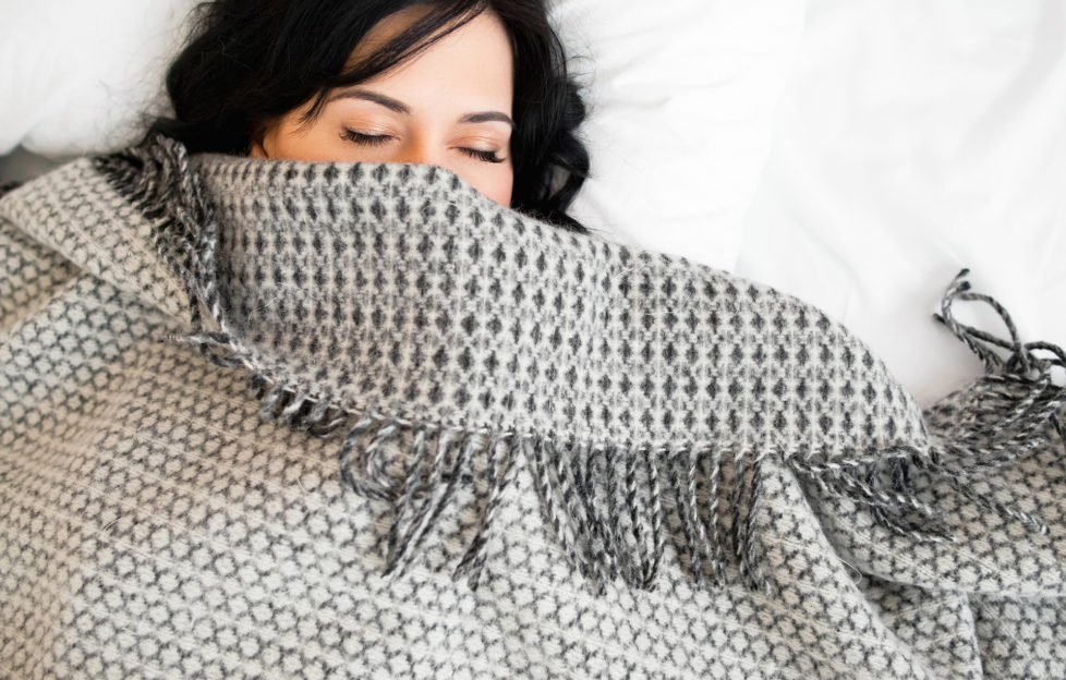 Half face of sleeping brunette under blanket