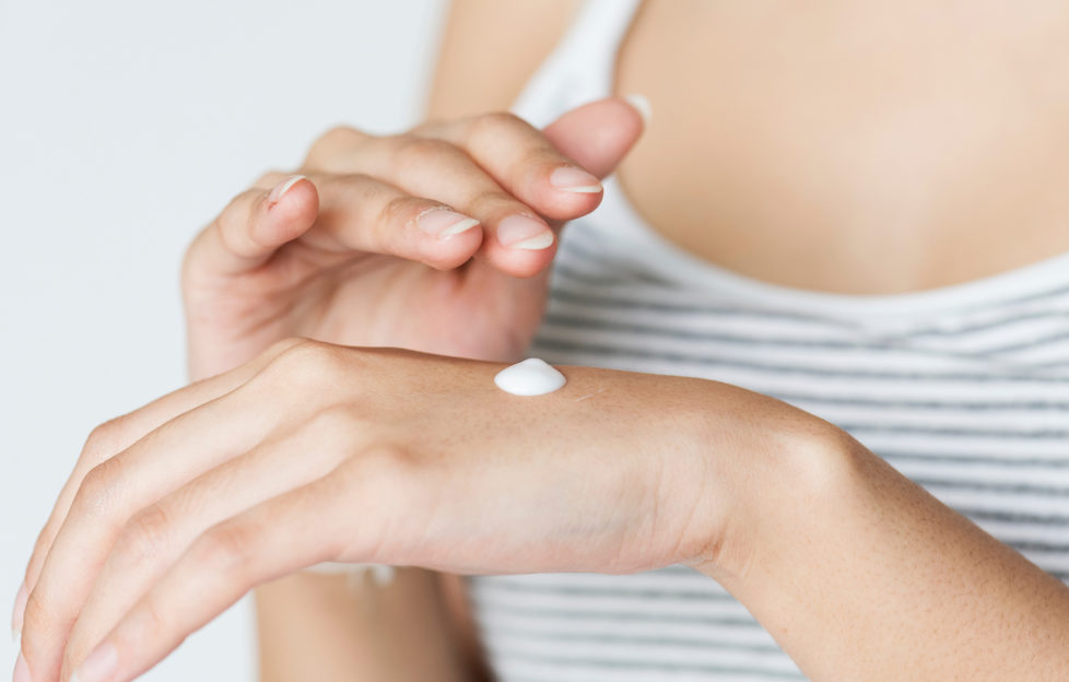 Woman rubbing cream into hand.