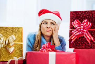 Worried woman surrounded by Christmas presents.