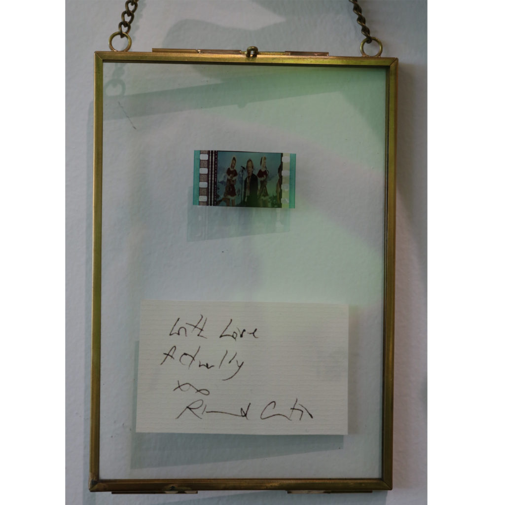 A film cell from Love Actually, in a frame with a signature of director Richard Curtis