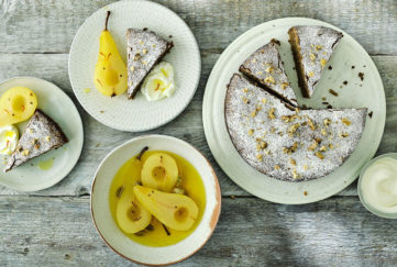 Sugar-dusted cake, 3 slices cut, dish of golden poached pears and 2 small plates with cake slice and a pear