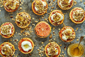 13 grapefruit halves, most topped with golden granola and yogurt