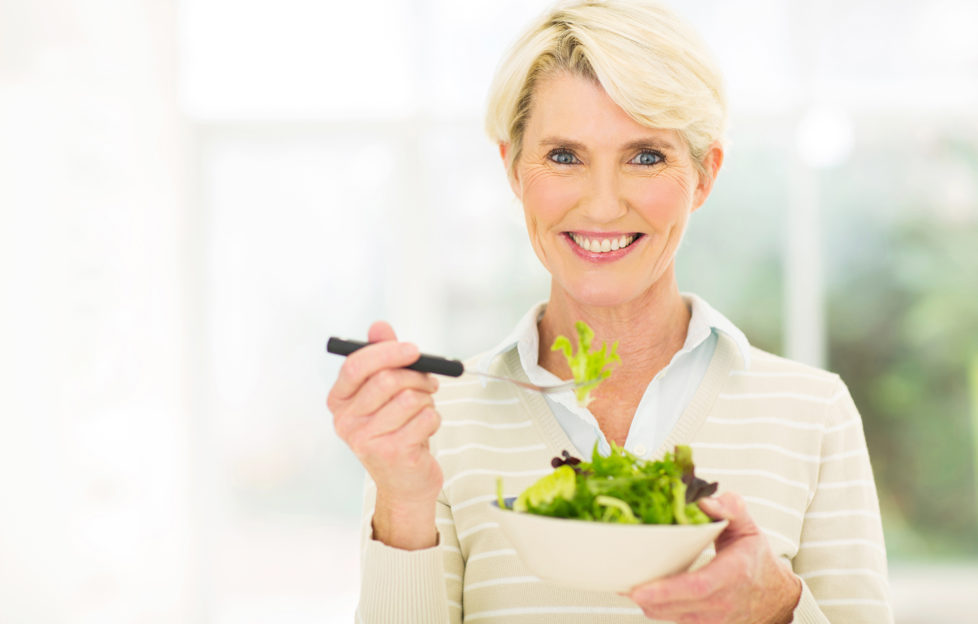 beautiful senior female vegetarian eating salad