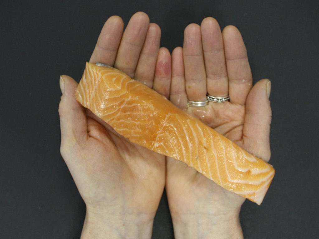 Hands holding salmon