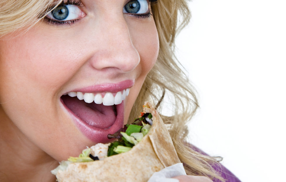 Woman eating a sandwich wrap