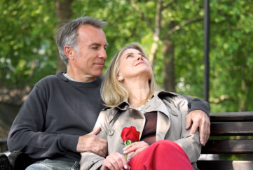 Loving mature couple sitting on park bench Pic: Istockphoto