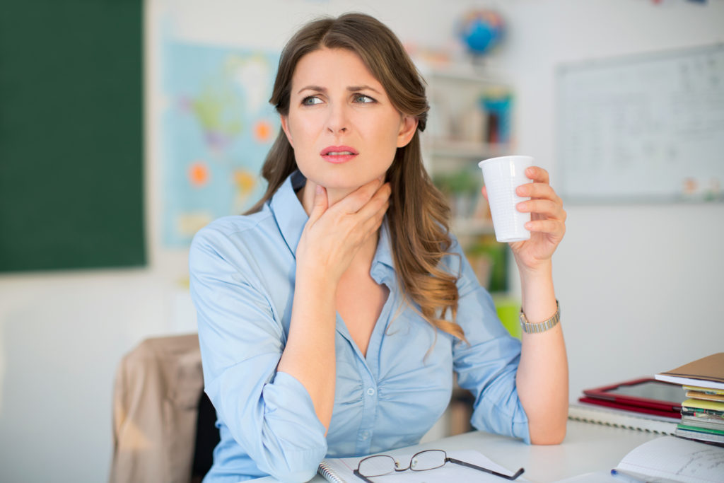 Woman with a sore throat and water