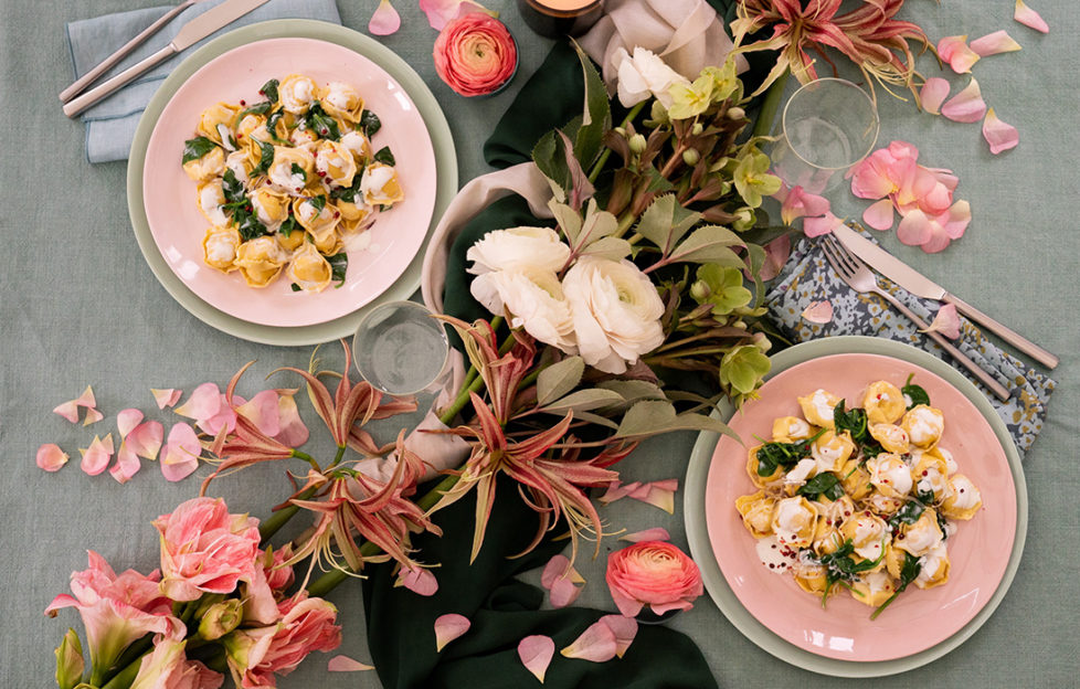 Pasta meal for two with flowers on table