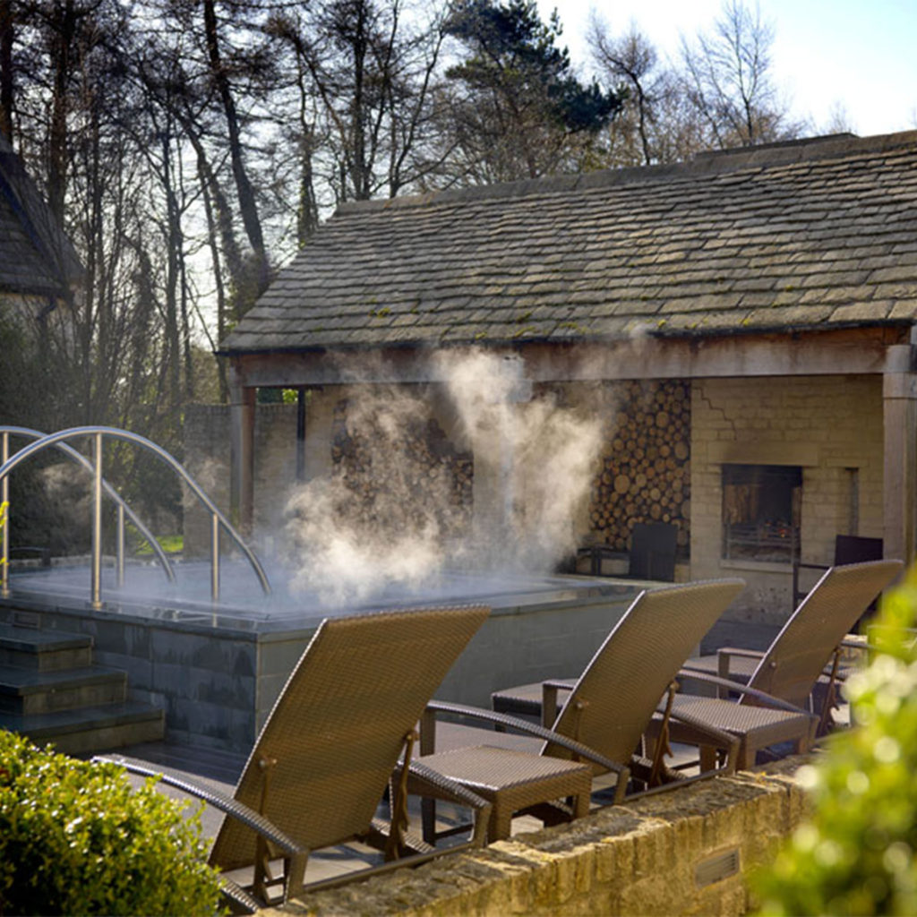 Steaming outdoor hot tub, sun loungers and beautiful old woodshed at Calcot Manor