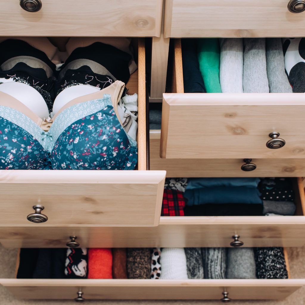 Drawers pulled out showing neatly arranged bras, vests etc