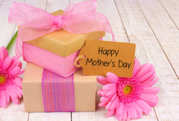 Handmade gift boxes with Happy Mother's Day tag and flowers on white wood Pic: Istockphoto