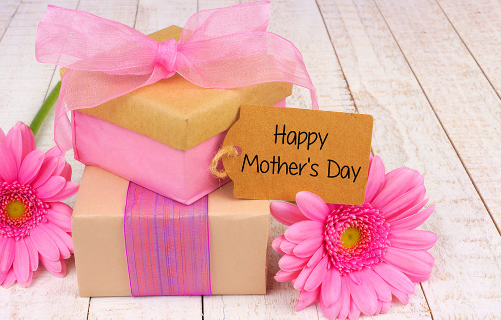 Handmade gift boxes with Happy Mother's Day tag and flowers on white wood Pic: Istockphoto