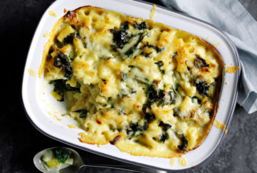 Oval dish of baked macaroni cheese with kale