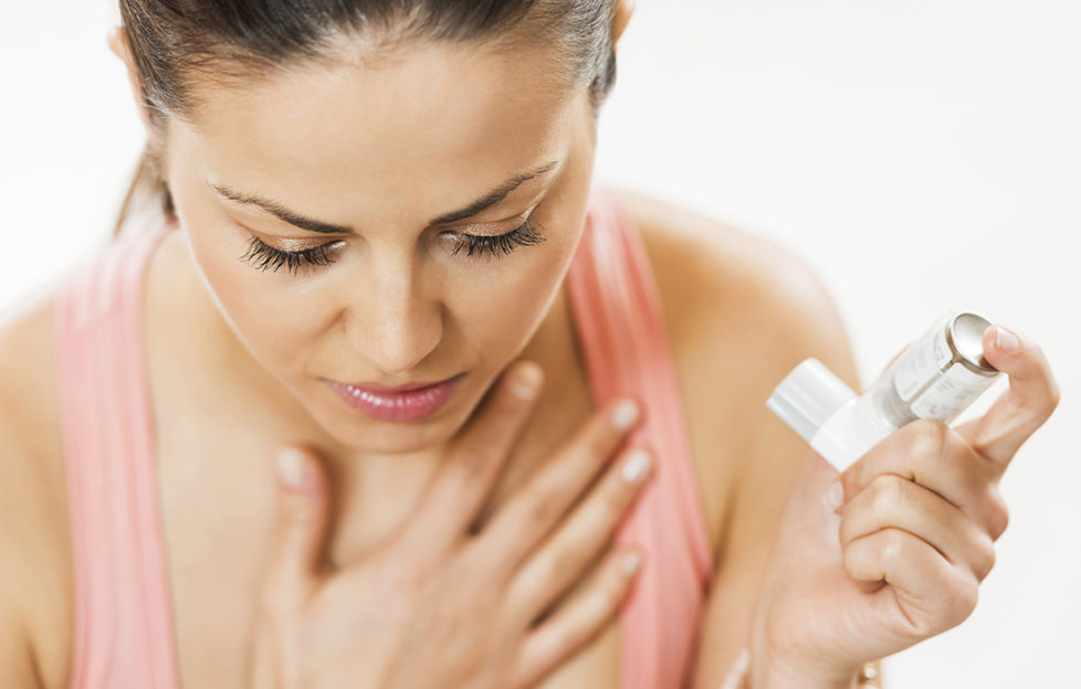 Young woman having asthma attack. She is holding asthma inhaler. Pic: Istockphoto