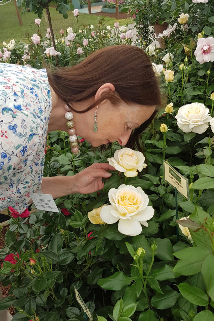 Woman bending down to smell roses