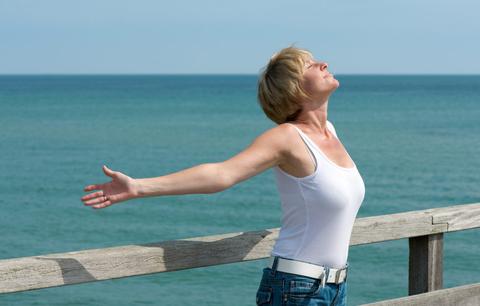 Woman with arms raised and breathing deeply