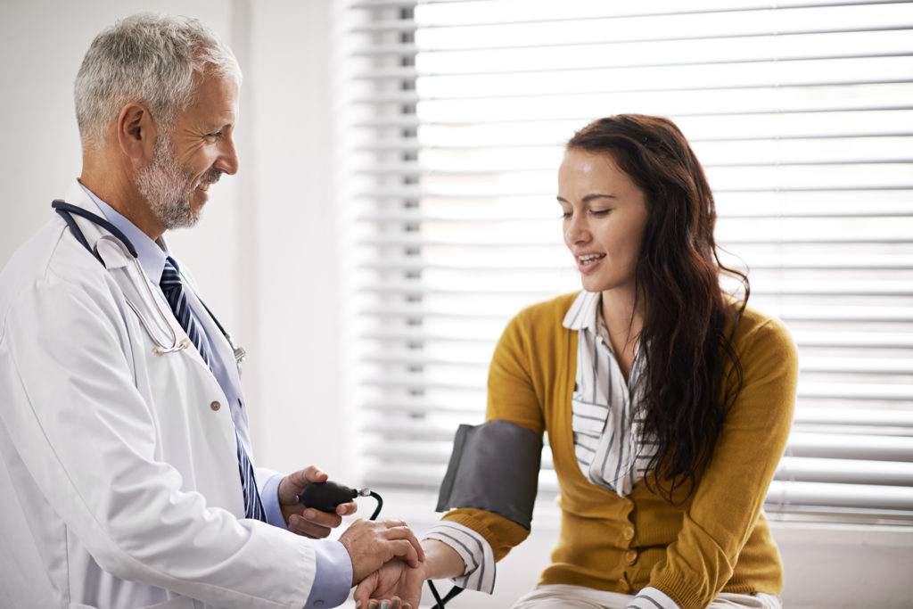 Cropped shot of a doctor checking a patient's blood pressure