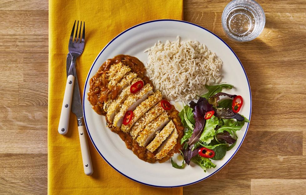 Golden breaded chicken brest, cut in slices, on bed of rich curry sauce with portion of rice and green salad with red chilli