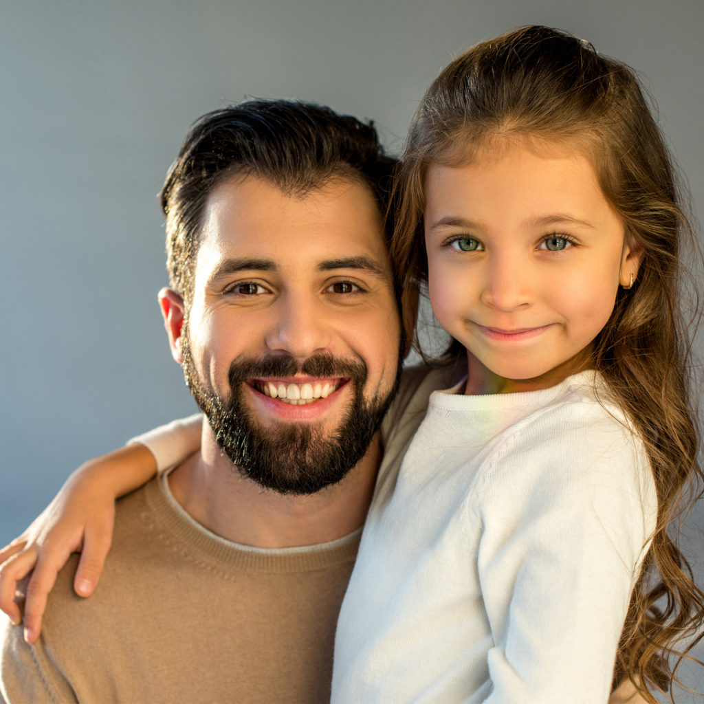 portrait of happy father and daughter looking at camera